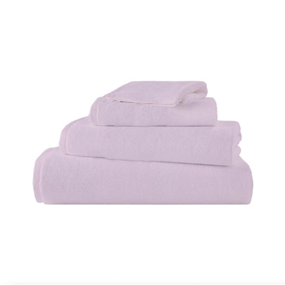Pile de serviettes en coton Brodo dans différentes nuances neutres, parfaites pour une décoration de salle de bain raffinée.
