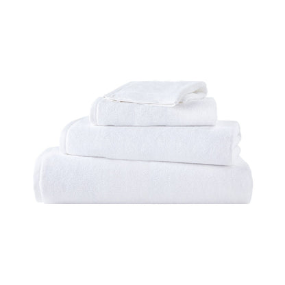 Serviette Brodo en coton moelleux soigneusement pliée sur une étagère de salle de bain élégante.
